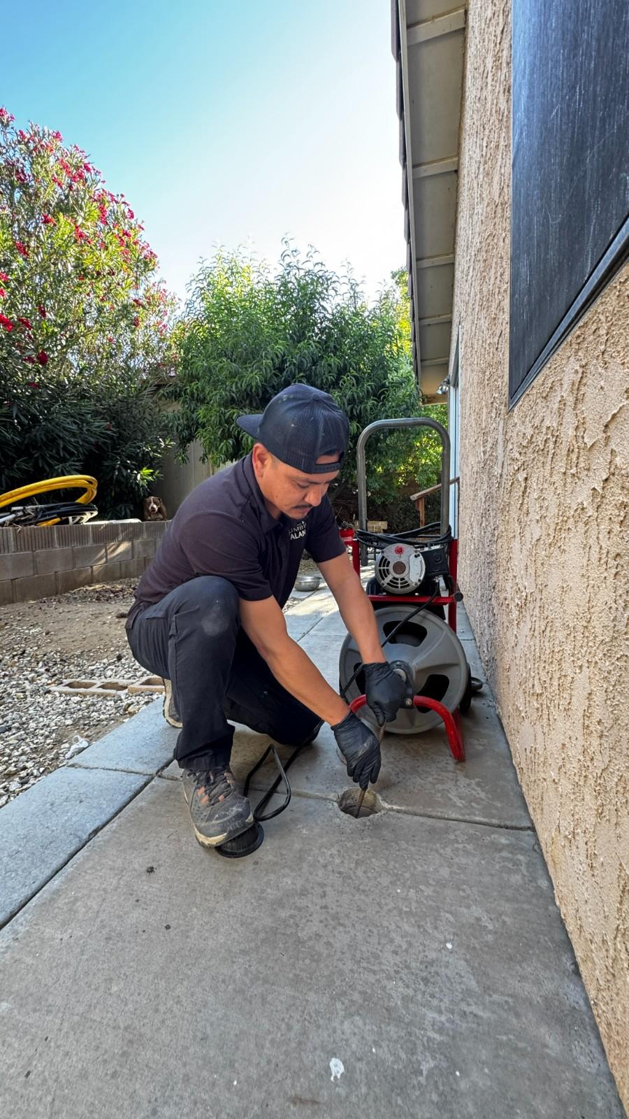 Plumber clearing a drain line with a sewer snake