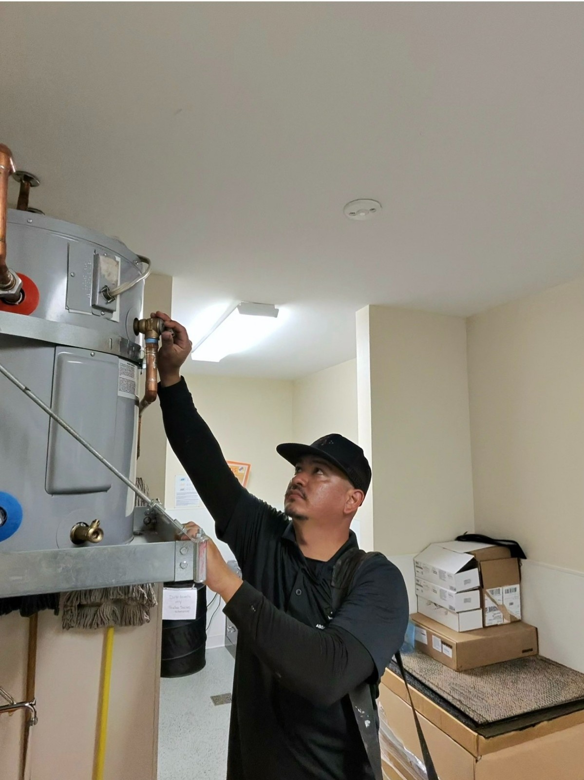Plumber adjusting valves on a commercial water heater