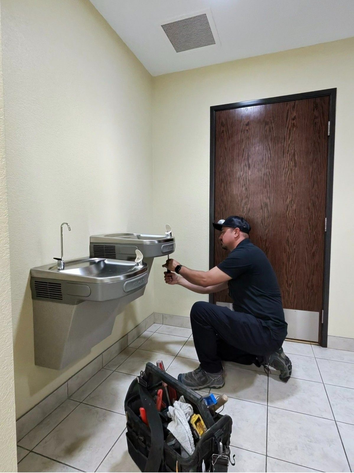 Plumber repairing a commercial drinking fountain