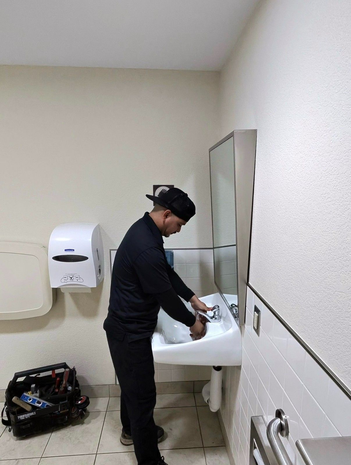 Plumber testing a commercial sink faucet