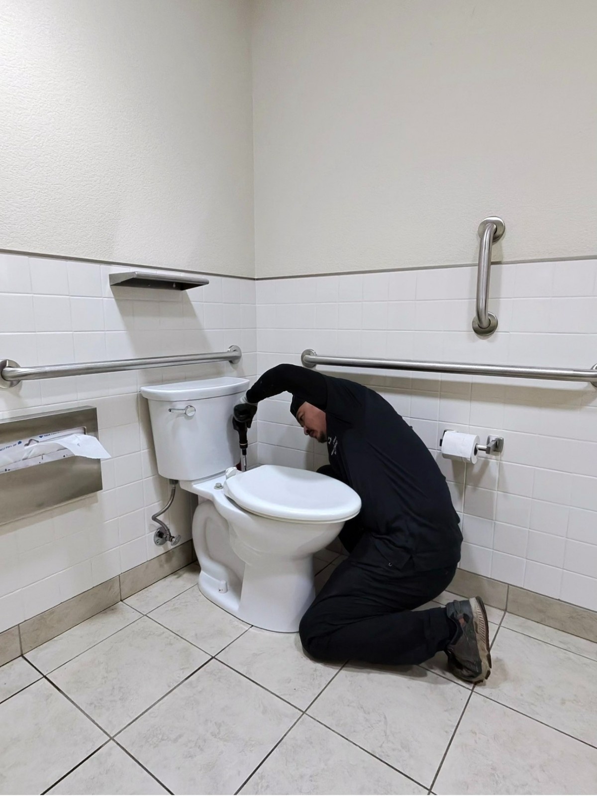 Plumber installing a commercial toilet